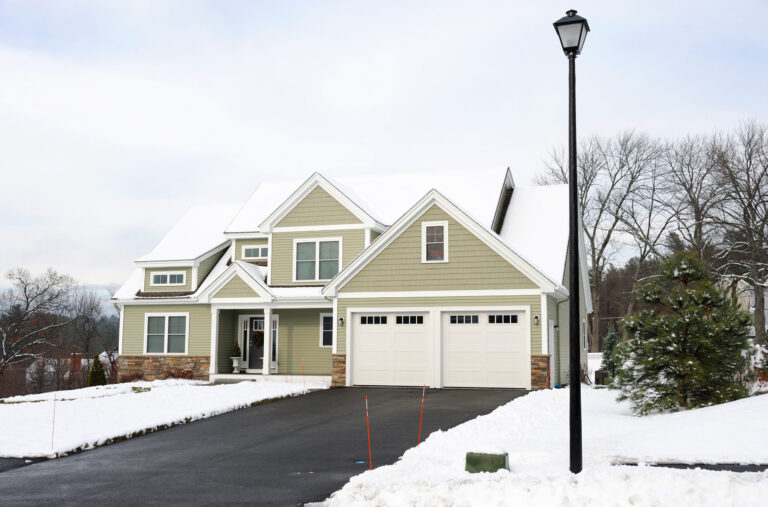 House with a snowy yard and a clear driveway